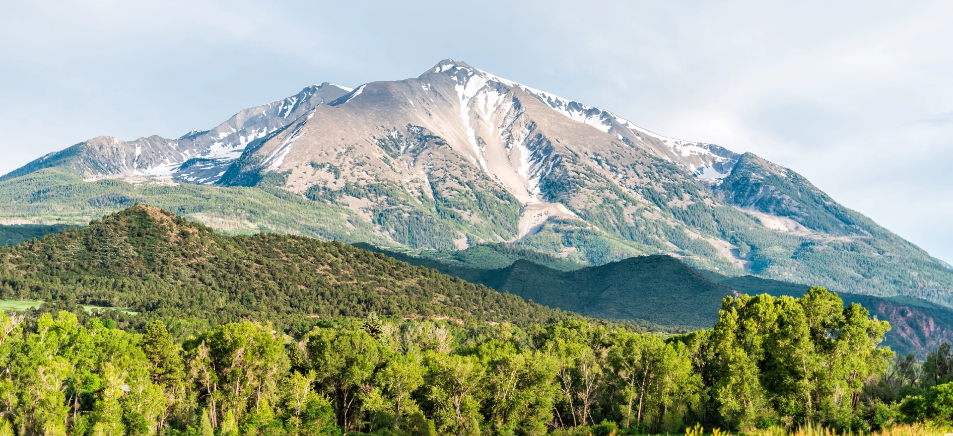 Mountain landscape with green forest foreground.